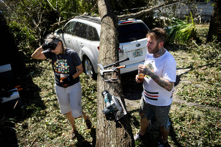 Tampak sebuah mobil rusak akibat tertimpa pohon yang tumbang akibat terjangan Topan Michael. Afp Photo/Brendan Smialowski