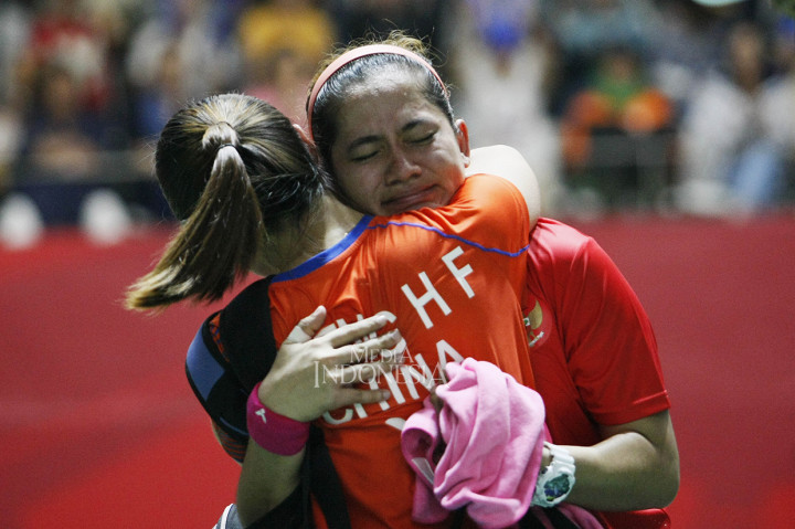 Pebulu tangkis Indonesia Leani Ratri Oktila berusaha menahan tangis ketika dipeluk lawannya seusai bertanding melawan pebulu tangkis Tiongkok Cheng Hefang pada final bulu tangkis tunggal putri SL4 Asian Para Games 2018 di Istora GBK, Senayan, Jakarta.