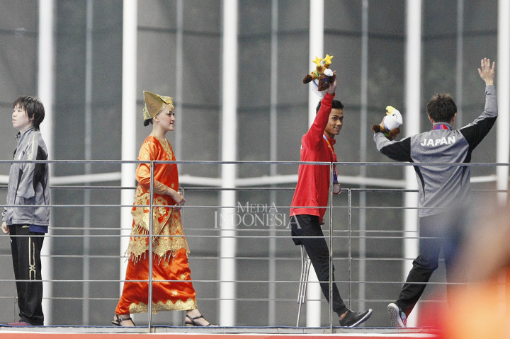 Perenang nasional Jendi Pangabean (merah) menerima medali perak yang diraihnya pada final renang 100 meter gaya dada putra S9 Asian Para Games 2018 di Stadion Akuatik GBK, Senayan, Jakarta.