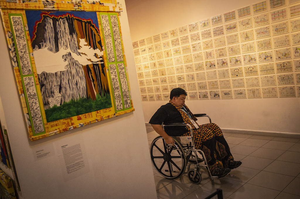Pengunjung melintas di antara karya yang ditampilkan dalam Pameran Aneka Rupa Lima RSJ bagian dari Festival Bebas Batas 2018 di Galeri Nasional, Jakarta. Festival Bebas Batas 2018 merupakan bagian dari edukasi kepada publik bahwa para disabilitas memiliki peranan yang sama dalam kehidupan bermasyarakat.