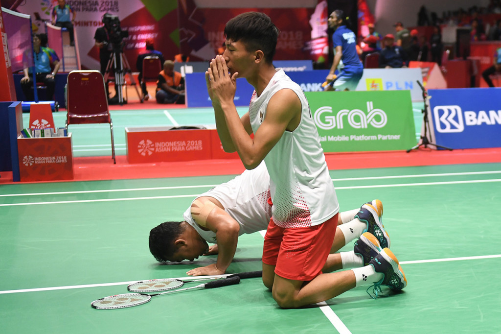 Pasangan pebulu tangkis Indonesia Deva Anrimushti (kanan) dan Hafizh Briliansyah (kiri) meluapkan kegembiraan usai menang atas pasangan Indonesia Suryo Nugroho/Listyanto Putra dalam partai final nomor ganda putra SU5 Asian Para Games 2018 di Istora Senayan, Jakarta.