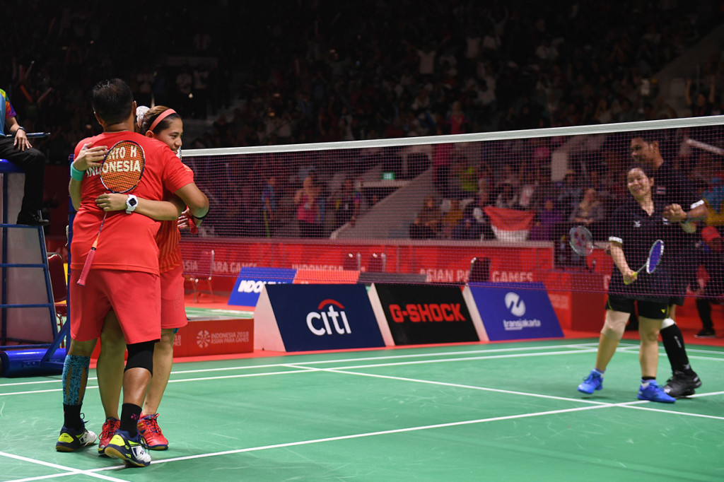 Pasangan pebulu tangkis Indonesia Leani Ratri Oktila (kanan) dan Hary Susanto (kiri) meluapkan kegembiraan usai menang atas pasangan Thailand Siripong Teamarrom/Nipada Saensupa dalam partai final bulu tangkis nomor ganda campuran SL3-SU5 Asian Para Games 2018 di Istora Senayan, Jakarta.