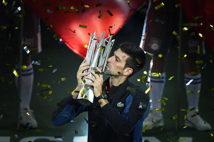 Petenis Serbia Novak Djokovic mencium trofi juara yang baru direbutnya di turnamen Shanghai Masters, Minggu, 14 Oktober 2018.