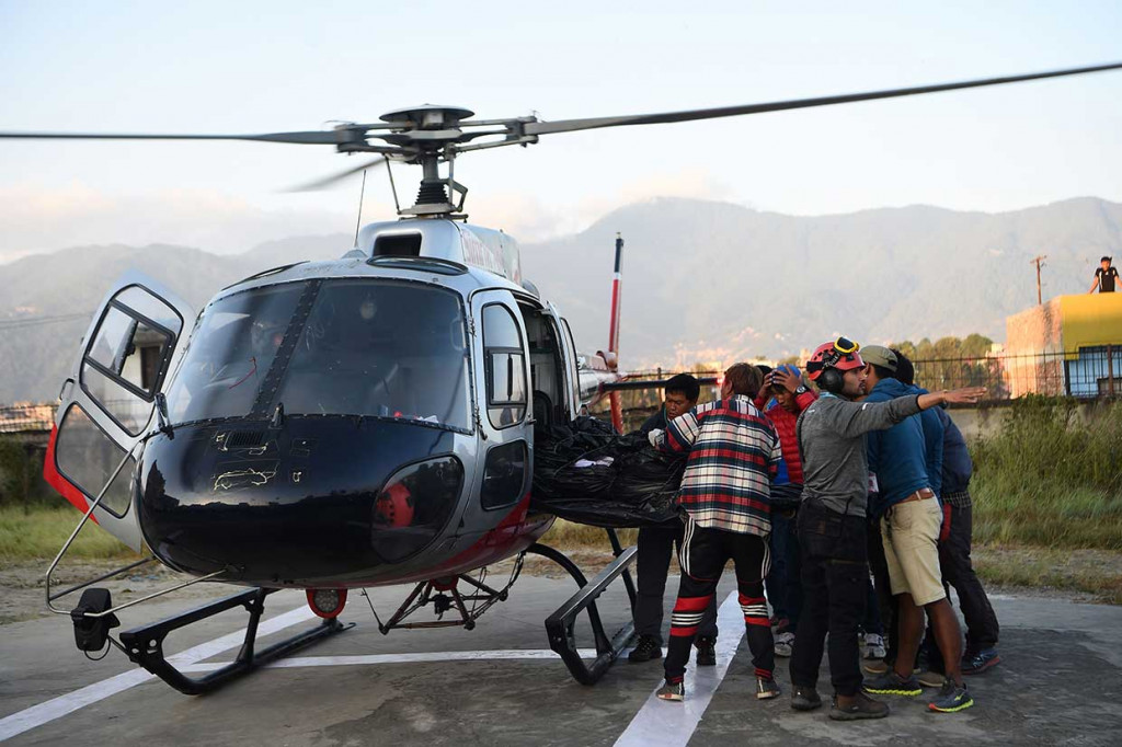 Relawan mengangkat jenazah para pendaki Korsel dan Nepal dari helikopter setelah dievakuasi dari Gunung Gurja, di Rumah Sakit Teaching, Kathmandu, Nepal, Minggu, 14 Oktober 2018. 