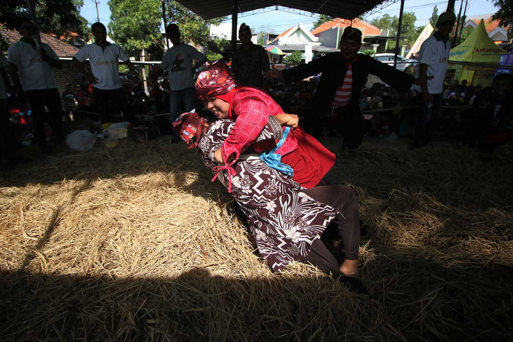 Gulat okol bisa diikuti semua kalangan umur dan gender. Pertarungan adu kekuatan ini digelar di atas sebuah arena yang dipenuhi tumpukan jerami, dengan iringan alunan gamelan.