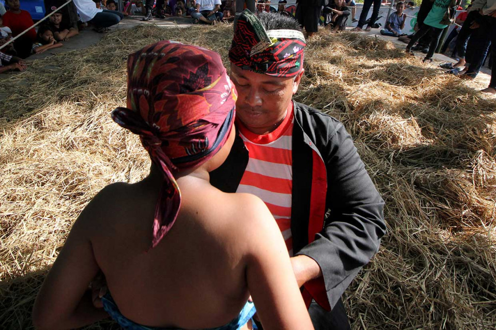 Sebelum bertanding, para peserta terlebih dahulu memakai ikat kepala atau udeng dan selendang yang diikatkan pada bagian perut sebagai pegangan untuk saling menjatuhkan. 