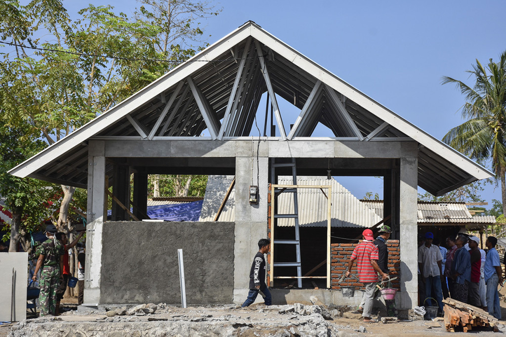 Sejumlah anggota TNI bersama warga menyelesaikan pembangunan Rumah Instan Sederhana Sehat (RISHA) di Dusun Pedamekan, Desa Belanting, Kecamatan Sambelia, Lombok Timur, NTB.