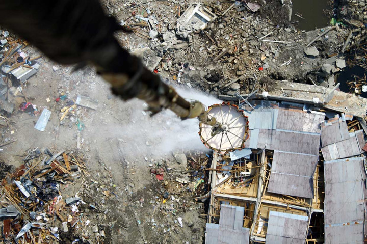 Helikopter Badan Nasional Penanggulangan Bencana (BNPB) menyemprotkan cairan desinfektan melalui udara dengan metode water bombing di titik lokasi gempa likuifaksi, Balaroa dan Sigi, Sulawesi Tengah, Kamis, 18 Oktober 2018.