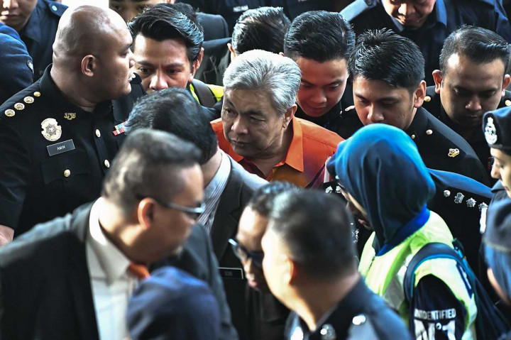 Mantan Wakil Perdana Menteri Malaysia Ahmad Zahid Hamidi dikawal polisi tiba di sebuah pengadilan di Kuala Lumpur untuk menjalani sidang dakwaan, Jumat, 19 Oktober 2018. 