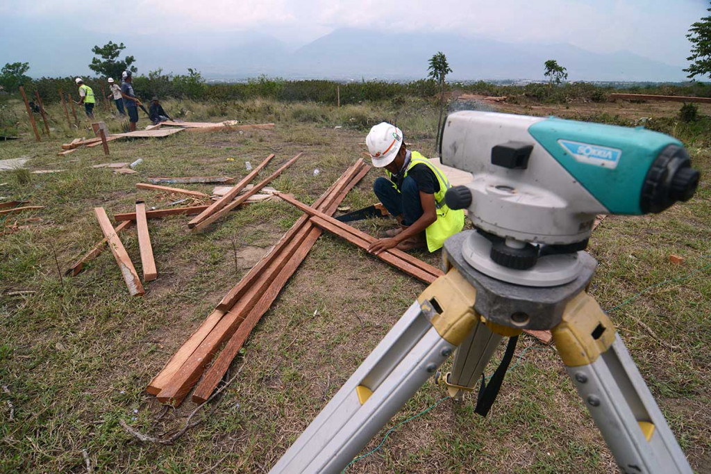 Pekerja mempersiapkan pembangunan huntara di kawasan terbuka Kelurahan Petobo. Pemerintah akan membangun sedikitnya 8.000 unit huntara yang setiap unitnya terdiri dari 12 keluarga untuk menampung korban gempa, tsunami, dan likuifaksi.