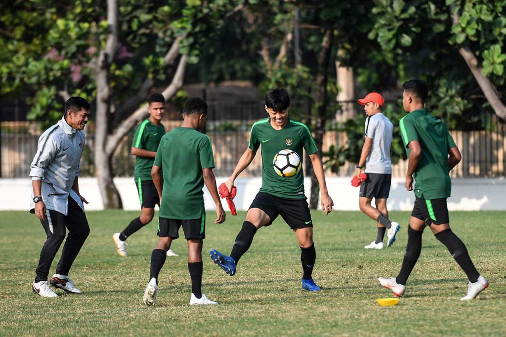 Pelatih Timnas Indonesia U-19 Indra Sjafri (kiri) memberikan arahan kepada sejumlah anak asuhnya saat menggelar latihan di Lapangan A Senayan, Jakarta, Sabtu, 20 Oktober 2018.