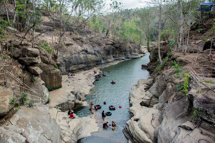 Pengunjung menikmati jernihnya air dengan berenang menggunakan ban di kawasan wisata alam Leuwi Kenit, Geopark Ciletuh, Kabupaten Sukabumi, Jawa Barat, Minggu, 14 Oktober.