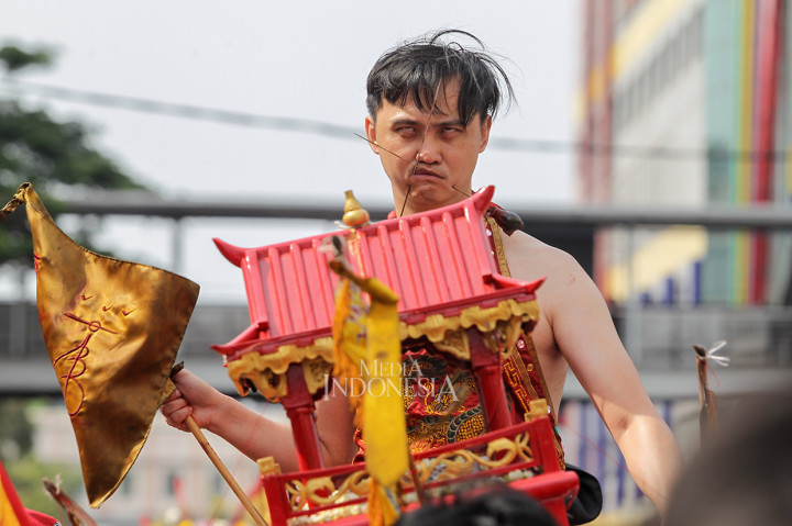 Warga Tionghoa melakukan atraksi Tatung saat mengikuti kirab budaya dan ruwat bumi dengan menggotong joli atau tandu toapekong di sepanjang ruas Jalan Hayam Wuruk, Jakarta.