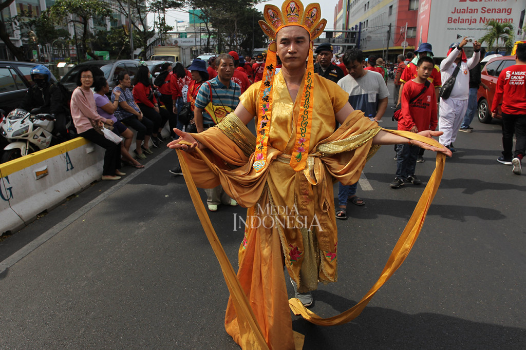 Warga Tionghoa mengenakan pakaian ulama Kong Hucu saat mengikuti kirab budaya dan ruwat bumi dengan menggotong joli atau tandu toapekong di sepanjang ruas Jalan Hayam Wuruk, Jakarta.