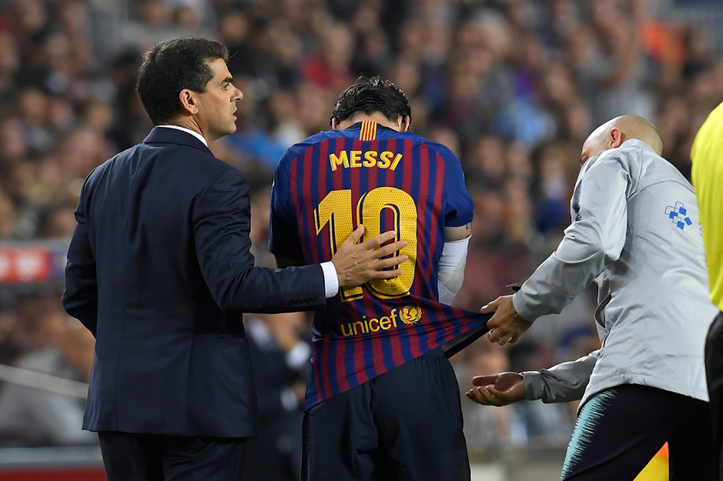 Lionel Messi meninggalkan lapangan setelah mengalami cedera selama pertandingan sepak bola liga Spanyol FC Barcelona melawan Sevilla FC di stadion Camp Nou.