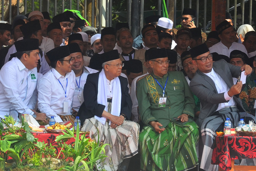 Calon Wakil Presiden nomor urut 01 Ma'ruf Amin (tengah) berswafoto dengan Ketua Umum PKB Muhaimin Iskandar atau Cak Imin (kedua kiri), Gubernur Jawa Barat Ridwan Kamil (kanan) dan Ketua Umum Pengurus Besar Nahdlatul Ulama (PBNU) Said Aqil Siroj (kedua kanan) saat menghadiri Apel Upacara Hari Santri Nasional di Lapangan Dadaha, Kota Tasikmalaya, Jawa Barat.