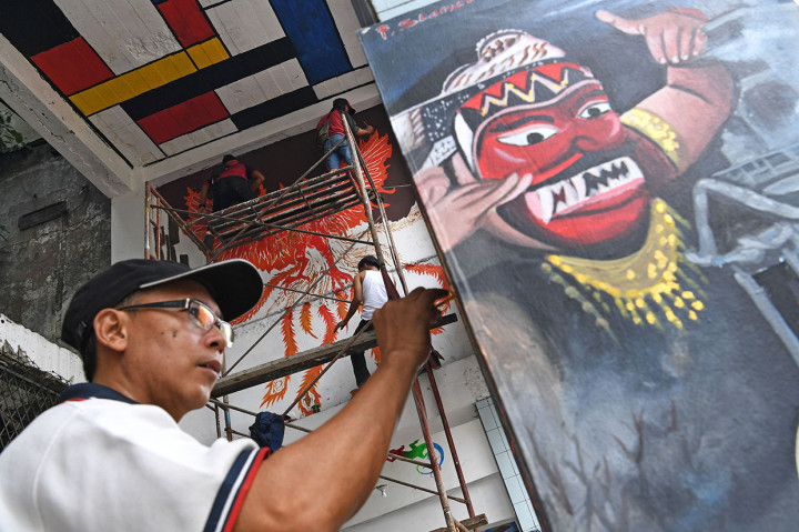 Seniman jalanan melukis mural di Jalan Pintu Besar Selatan Kawasan Kota Tua, Jakarta. 