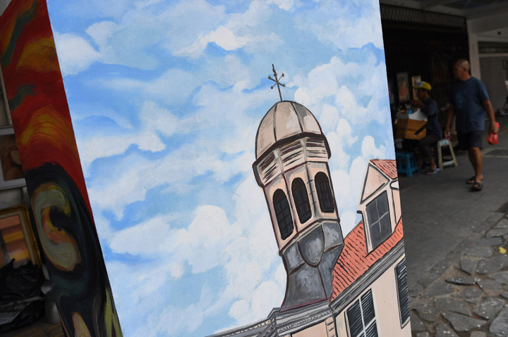 Pengunjung melintasi mural di Jalan Pintu Besar Selatan Kawasan Kota Tua, Jakarta.
