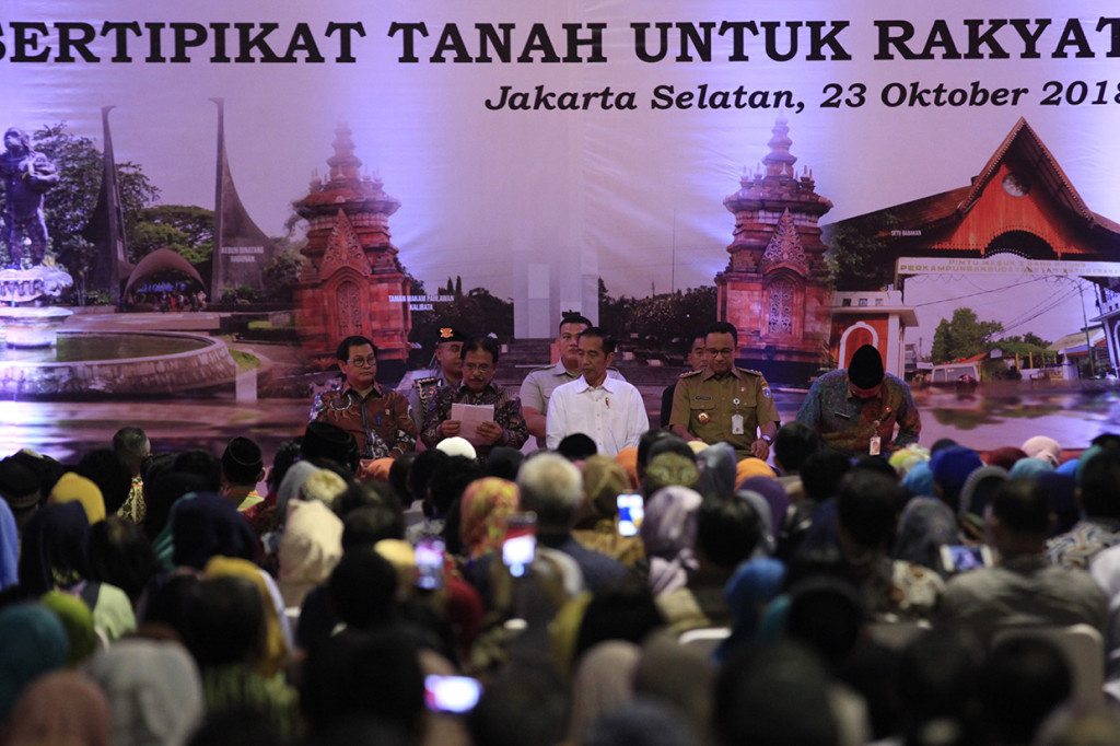 Presiden Joko Widodo didampingi Sekretaris Kabinet, Pramono Anung, Menteri Agraria dan Tata Ruang/Kepala Badan Pertanahan Nasional (BPN), Sofyan Djalil, Gubernur DKI Jakarta Anies Baswedan saat acara Penyerahan Sertifikat Tanah Untuk Rakyat di lapangan bola Ahmad Yani, Kabayoran Lama Selatan, Jakarta Selatan.
