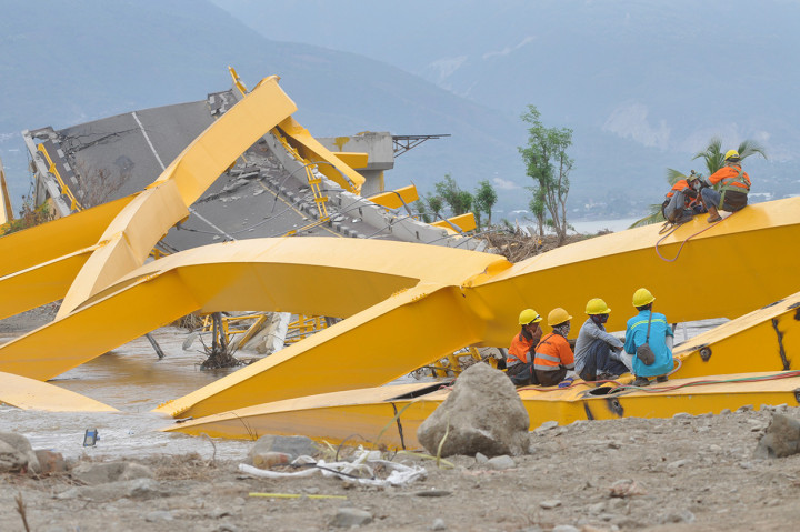 Pekerja memotong besi Jembatan Kuning yang ambruk diterjang tsunami di Palu, Sulawesi Tengah.