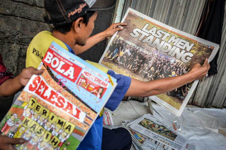 Warga membaca Tabloid Olahraga Bola edisi penutup atau terbitan terakhir di kawasan Kwitang, Senen, Jakarta, Jumat, 26 Oktober 2018. 