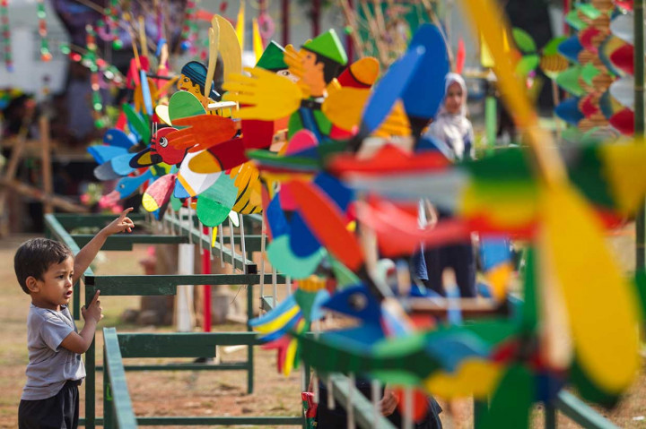 Seorang anak melihat-lihat kincir kayu pada acara Festival Kincir Angin di Karanganyar, Jawa Tengah, Sabtu, 27 Oktober 2018. 