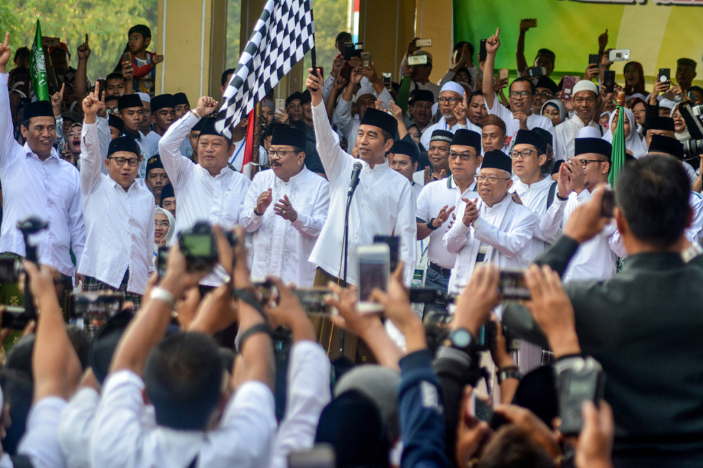 Presiden Joko Widodo (keempat kanan) didampingi Mustasyar PBNU sekaligus calon Wakil Presiden nomor urut 01 Ma'ruf Amin (kedua kanan), Kepala Kantor Staf Presiden Moeldoko (ketiga kanan), Menteri Tenaga Kerja Hanif Dhakiri (kanan), Menteri Pertanian Amran Sulaiman (kiri), Gubernur Jawa Timur Soekarwo (keempat kiri), Ketua Umum Partai Kebangkitan Bangsa Muhaimin Iskandar (kedua kiri) dan Bupati Sidoarjo Saiful Ilah (ketiga kiri) melepas Kirab Santri dan Jalan Sehat Sahabat Santri di alun-alun Sidoarjo, Jawa Timur. Antara Foto/Umarul Faruq