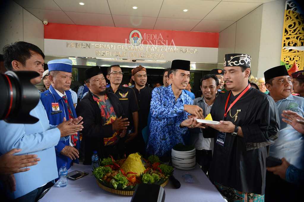 Deputi Bidang Pengembangan Pemuda Kemenpora, Asrorun Ni'am Sholeh (ketiga dari kanan) memberikan Nasi Tumpeng setelah memberikan penghargaan kepada para Wirausaha Muda pada acara peringatan 90 tahun Sumpah Pemuda di Komplek Kemenpora, Jakarta.