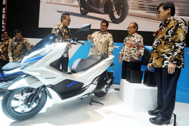 Menteri Perindustrian Airlangga Hartarto (ketiga kanan) melihat Honda PCX Electric didampingi Presiden Direktur PT Astra Honda Motor Toshiyuki Inuma (kedua kanan), Marketing Director Thomas Wijaya (keempat kanan), dan Ketua Umum Asosiasi Industri Sepedamotor Indonesia Johannes Loman di stan Honda saat pembukaan Indonesia Motorcycle Show (IMOS) 2018.