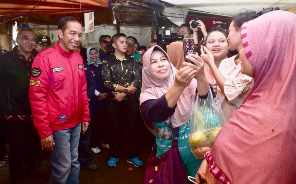 Dicegat warga yang sedang berbelanja dan mengajaknya berfoto bersama. 