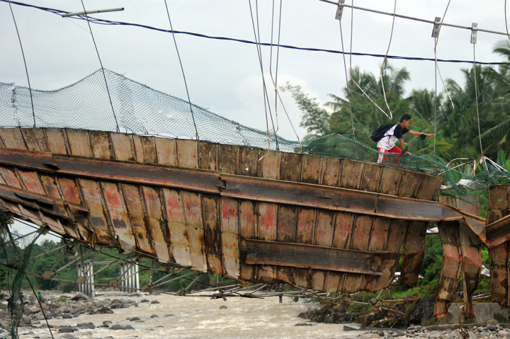 Seorang pelajar melewati jembatan yang rusak di Kelurahan Baringin, Lubuk Kilangan, Padang, Sumatera Barat.