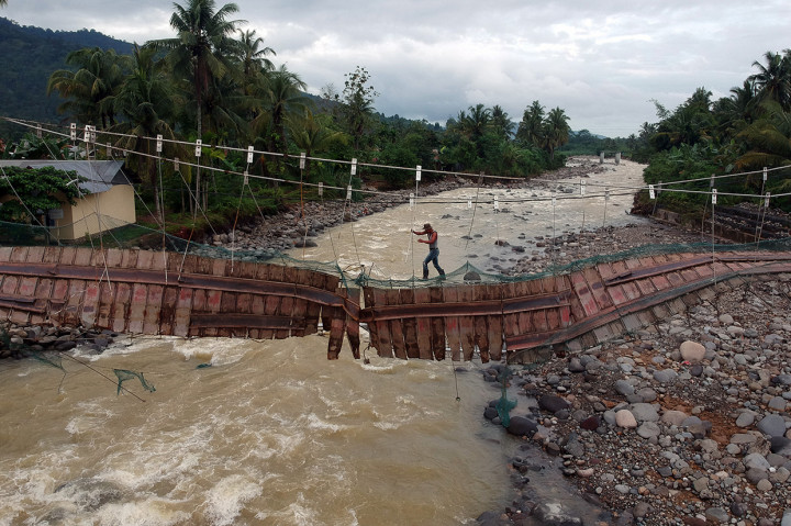 Jembatan darurat tersebut rusak akibat terjangan luapan sungai, namun warga nekat menggunakan jembatan itu untuk aktivitas sehari-hari.