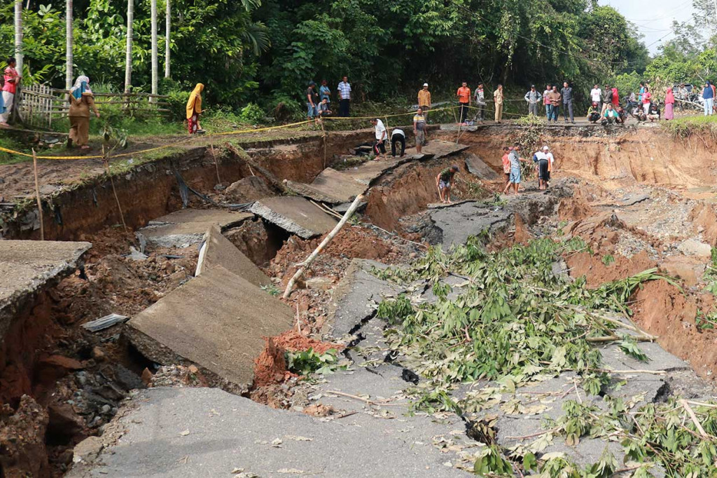 Warga bergotong-royong membersihkan jalan yang ambles di Nagari Kumanis, Kabupaten Sijunjung, Sumatera Barat, Senin, 5 November 18. 