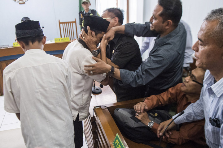 Dua terdakwa pengeroyokan Haringga Sirla yang berinisial AP (kiri) dan NSF (kedua kiri) memeluk pendamping seusai mengikuti sidang pembacaan putusan di Pengadilan Negeri Bandung, Jawa Barat.
