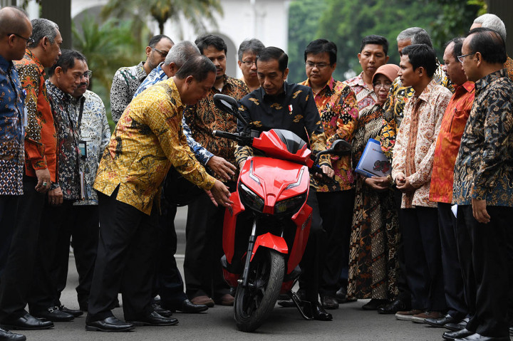 Presiden Joko Widodo (tengah) mendengarkan penjelasan dari Menristekdikti M Nasir (kelima kiri) sebelum menjajal motor listrik buatan dalam negeri 'Gesits' seusai melakukan audiensi dengan pihak-pihak yang terlibat proses produksi di halaman tengah Istana Kepresidenan, Jakarta.
