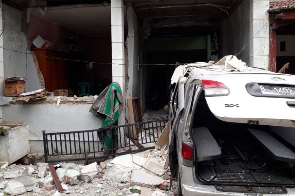 Sementara rumah dua lantai juga mengalami kerusakan yang cukup parah. Sebuah mobil minibus juga mengalami kerusakan.