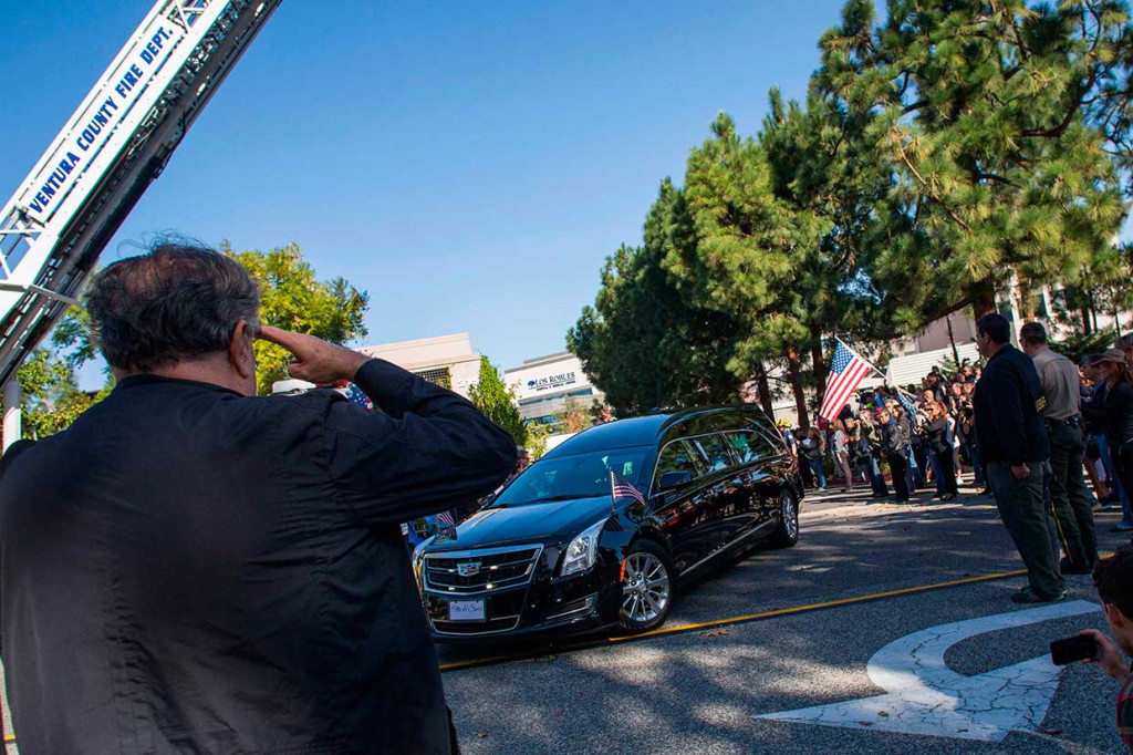 Warga memberi penghormatan saat iring-iringan mobil jenazah yang membawa mendiang Sheriff Ventura County Geoff Dean keluar dari sebuah rumah sakit di California. Geoff Dean merupakan salah satu korban tewas dalam penembakan di bar California.