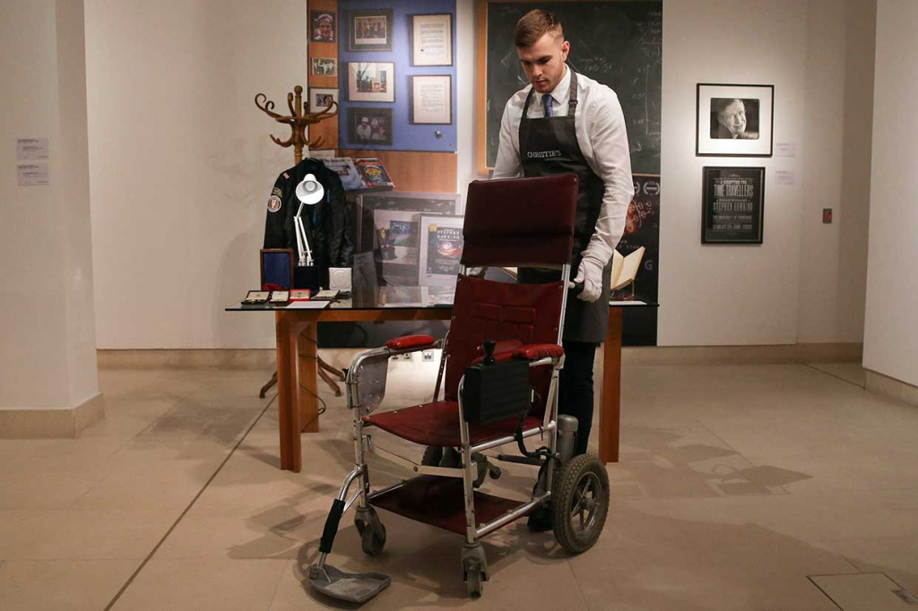 Petugas balai lelang memegang kursi roda bermotor, c.1988 milik ahli fisika teoritis Inggris, Stephen Hawking, di rumah lelang Christie di London.