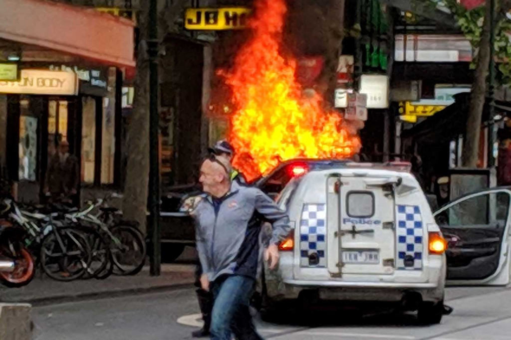 Seorang pria berlari menjauhi kendaraan yang terbakar di jalanan sibuk Bourke Street, Melbourne, setelah pengemudi menghentikan kendaraan dan kemudian menikam sejumlah orang. AFP Photo/Courtesy of Chris Newport