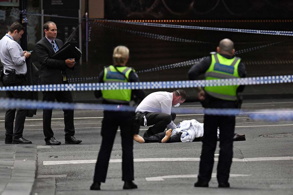 Polisi memeriksa jenazah korban penusukan di jalanan sibuk Bourke Street, Melbourne. Satu orang tewas dan dua lainnya luka-luka dalam insiden yang menurut polisi sebagai teror tersebut. AFP Photo/William West