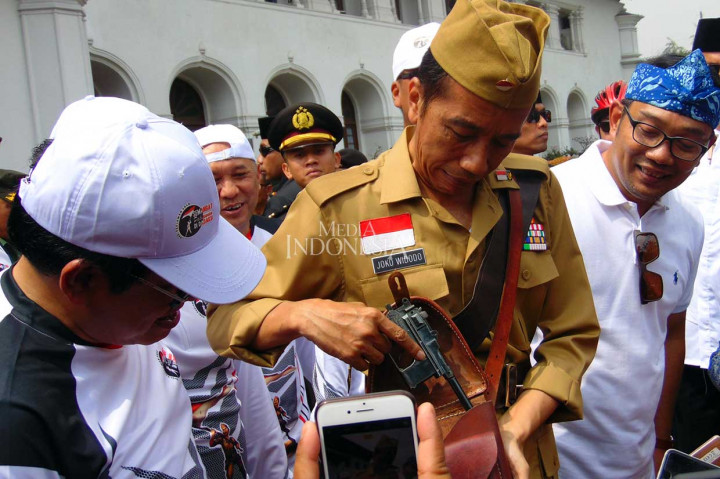 Tak hanya itu, dengan penuh canda Presiden pun menunjukkan sepucuk pistol yang digunakan sebagai atributnya saat bersepeda. 