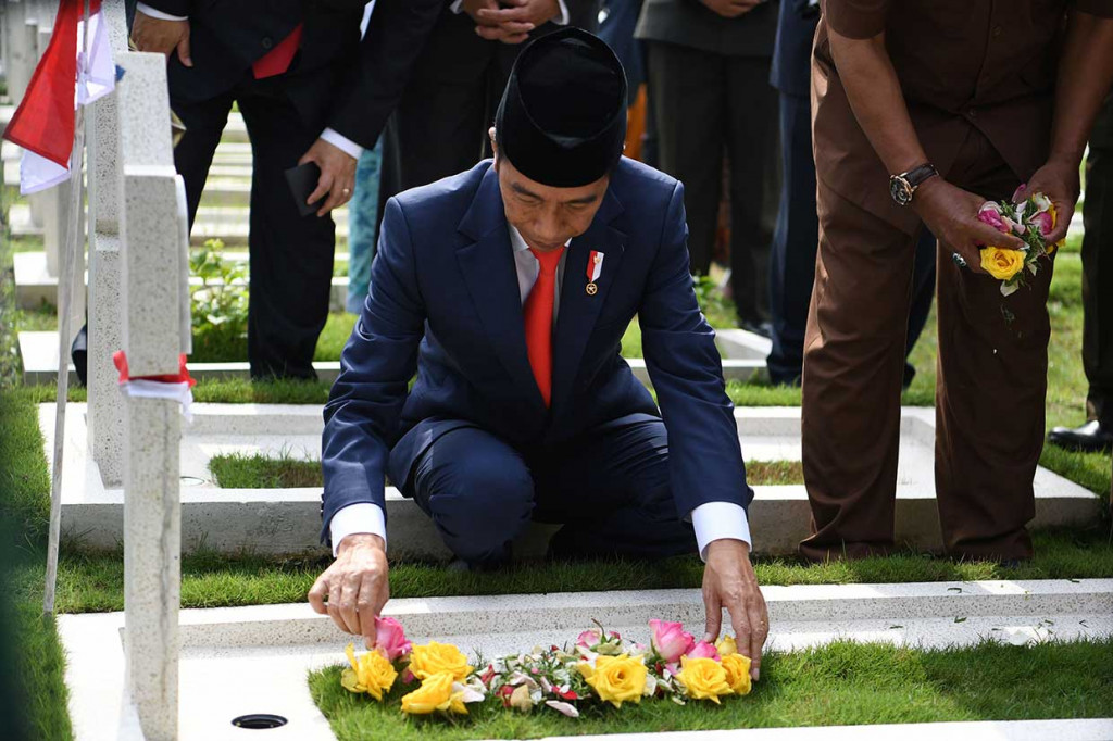 Presiden Joko Widodo melakukan tabur bunga di pusara pahlawan seusai menjadi inspektur upacara peringatan Hari Pahlawan di Taman Makam Pahlawan Cikutra, Bandung, Jawa Barat, Sabtu, 10 November 2018.