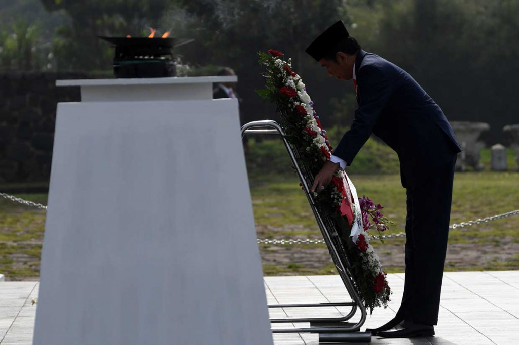 Jokowi meletakkan karangan bunga ketika menjadi inspektur upacara pada peringatan Hari Pahlawan di Taman Makam Pahlawan Cikutra, Bandung.