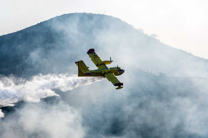 Petugas juga mengerahkan pesawat pembom air untuk memadamkan kebakaran.