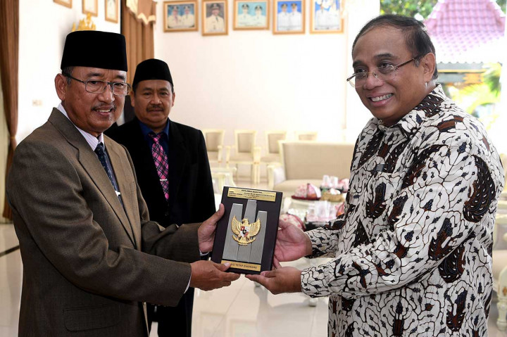 Cucu Pahlawan Nasional Mayjen TKR HR Mohamad Mangoenprodjo, Indroyono Soesilo (kanan), menyerahkan plakat Pahlawan Nasional Mayjen TKR HR Mohamad Mangoenprodjo kepada Wakil Bupati Ponorogo Soedjarno seusai upacara peringatan Hari Pahlawan. Antara Foto/Zabur Karuru