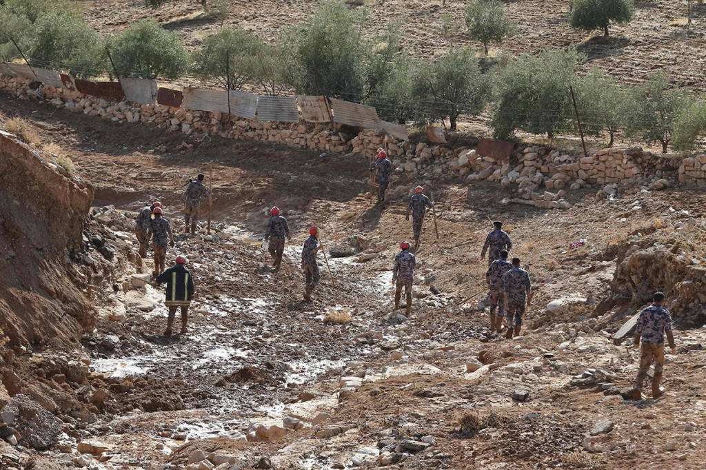Tim penyelamat mencari orang hilang setelah badai hujan menyebabkan banjir bandang di kota Madaba, Yordania. Afp Photo/KhalilMazraawi