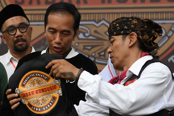 Presiden Joko Widodo menerima rompi dari Ketua Pelaksana Deklarasi Jabar Kondusif Budi Dalton seusai deklarasi di Bandung, Jawa Barat.