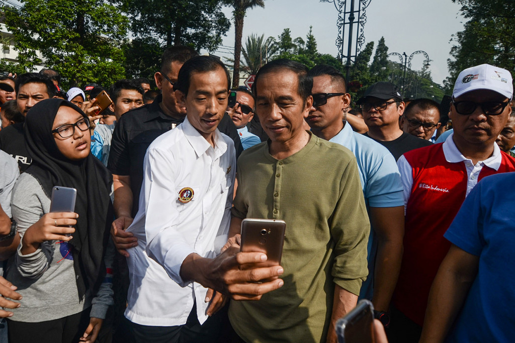 Presiden Joko Widodo (kanan) berfoto bersama warga saat melakukan kunjungan di