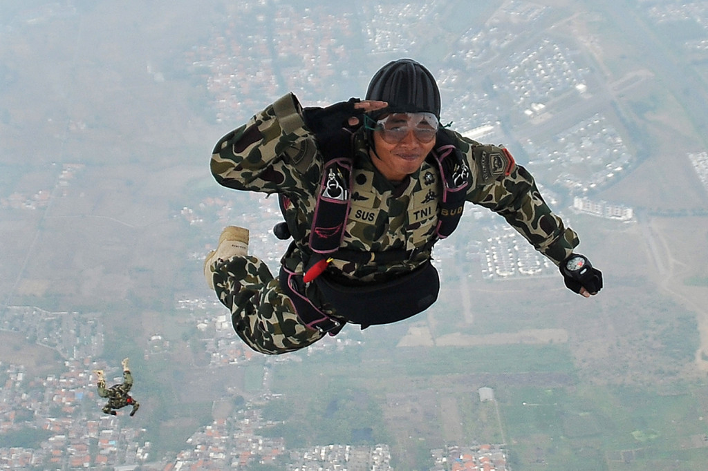 Seorang prajurit Korps Marinir TNI AL memberi hormat ketika melompat mengikuti terjun bebas (free fall) pesawat udara Cassa U-6212 Skuadron Udara 600 Wing Udara-1 Puspenerbal diatas Bhumi Marinir Karangpilang Surabaya, Jawa Timur.