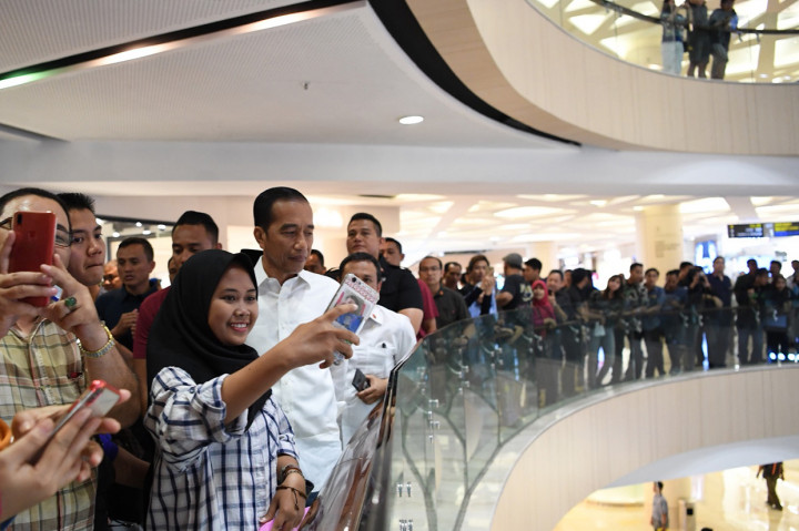 Jokowi tampak santai mengenakan kemeja putih polos, celana jin, dan sneakers. Mantan Gubernur DKI Jakarta itu tak canggung melayani permintaan pengunjung untuk berfoto dan bersalaman.